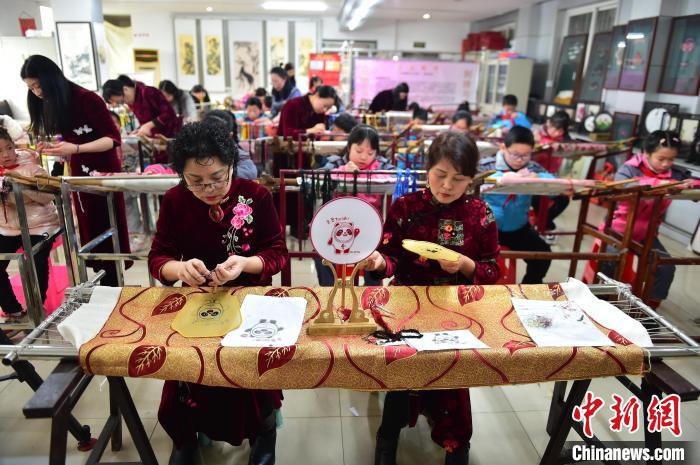 江西省級非遺豫章繡傳承人手把手指導小學生繡制2022年北京冬奧會吉祥物“冰墩墩”形象?！∮髟屏?攝