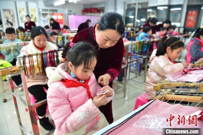 江西省級非遺豫章繡傳承人手把手指導小學生繡制2022年北京冬奧會吉祥物“冰墩墩”形象?！∮髟屏?攝