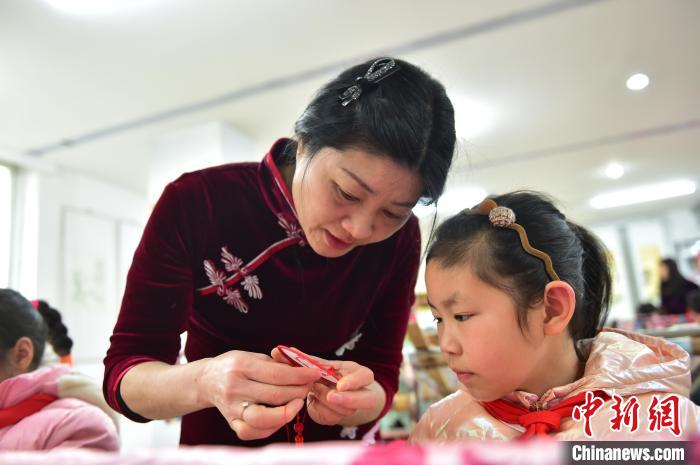 江西省級非遺豫章繡傳承人手把手指導小學生繡制2022年北京冬奧會吉祥物“冰墩墩”形象?！∮髟屏?攝