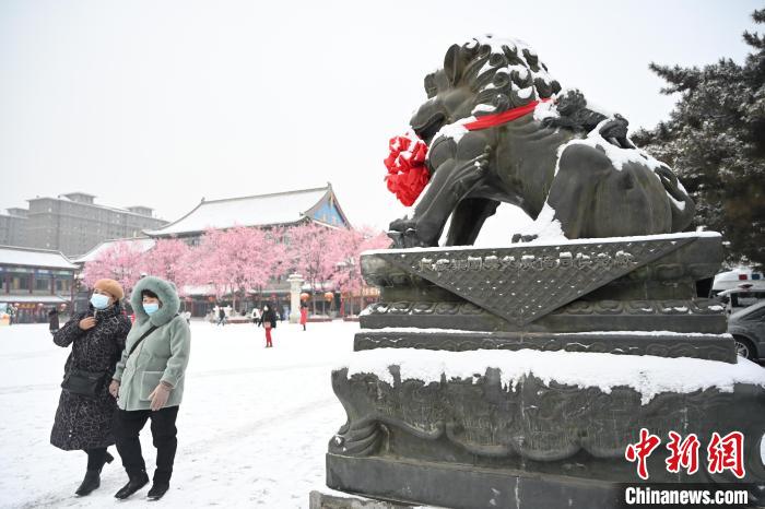 2月13日，民眾在呼和浩特市大召廣場雪中漫步?！⑽娜A 攝