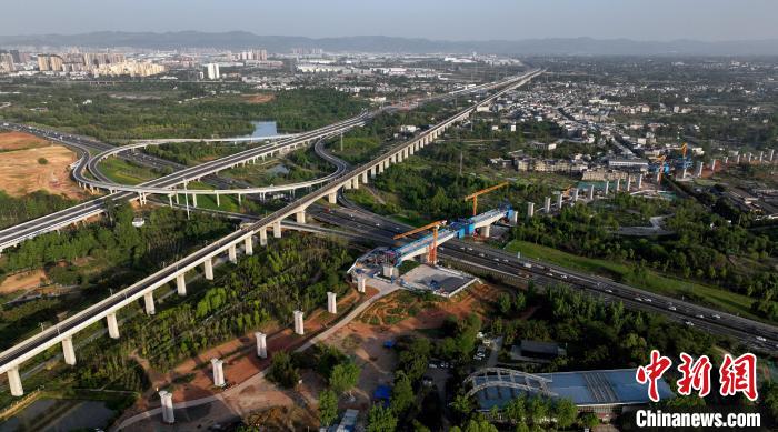 航拍正在建設的跨越成都繞城高速公路連續梁施工現場，旁邊依次為已運營的成渝高速鐵路和機場高速公路?！⒅铱?攝