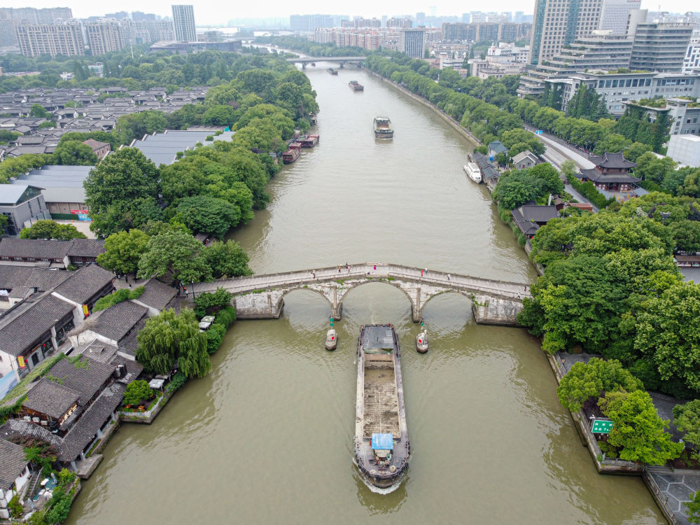 5月27日，一艘貨船駛過京杭大運河南端標志建筑杭州拱宸橋。(無人機照片)新華社記者江漢 攝