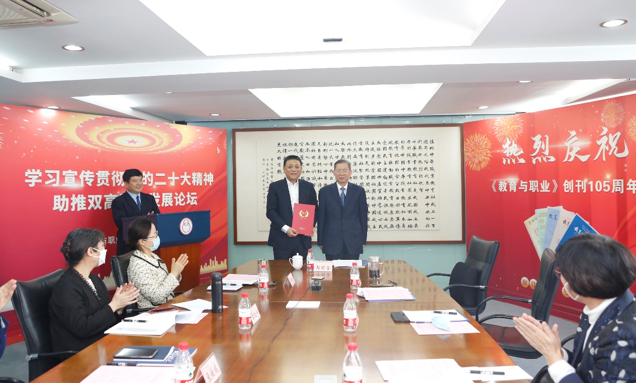郝明金為《教育與職業》雜志編委代表陳曉明頒發聘書。中華職教社供圖