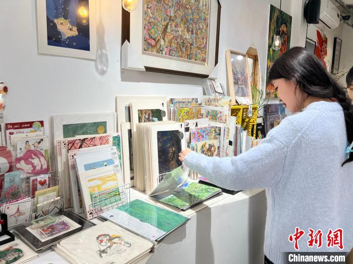 圖為藝術品商店內，顧客挑選插畫作品?！＄婌?攝