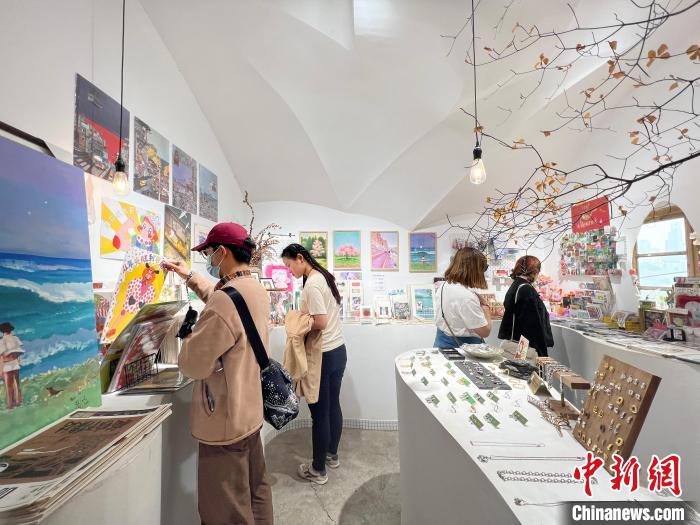 圖為藝術品商店內，顧客挑選插畫作品?！＄婌?攝