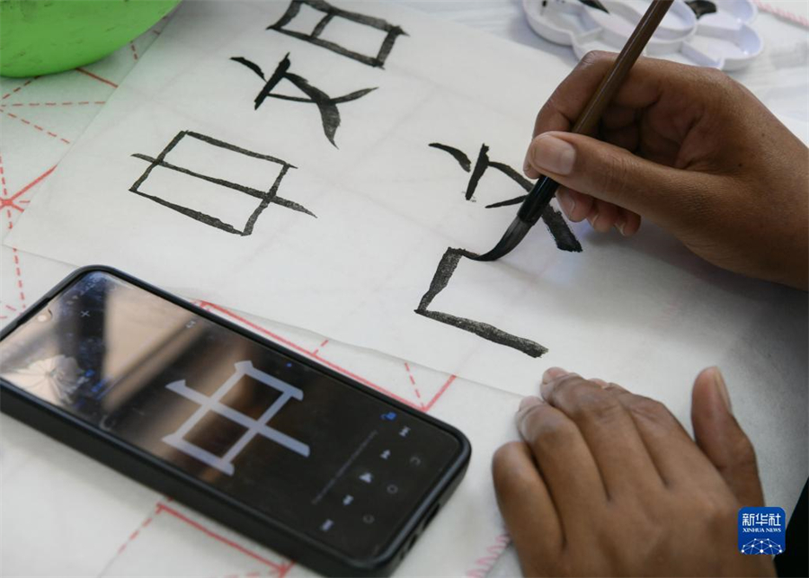4月18日，肯尼亞學生在內羅畢大學孔子學院舉辦的活動上寫毛筆字?？夏醽唭攘_畢大學孔子學院18日舉辦“中文，增進文明對話”主題活動，慶祝即將到來的第14個聯合國中文日?？夏醽唽W生參與互動，進行書法、剪紙、唱中文歌等活動。新華社記者 韓旭 攝