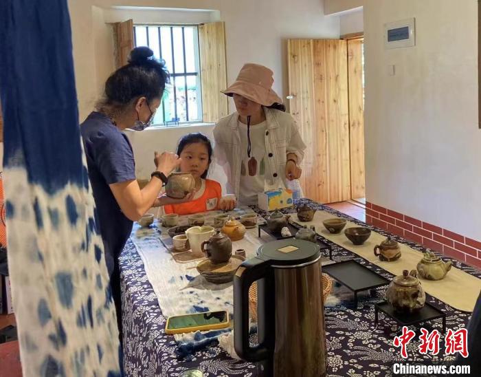 圖為：游客正在咨詢臺灣柴燒作品?！∪~秋云 攝