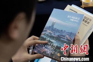 參展觀眾閱讀浙江文旅手冊?！《≌裾?攝