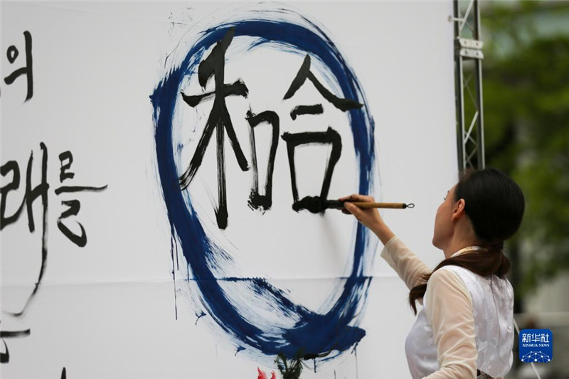 5月30日，在韓國首爾舉辦的“中日韓合作之日”慶?；顒又?，表演者進行中日韓精神——2023年度漢字“和合”書法表演。新華社記者 王益亮 攝