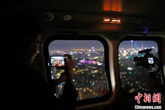 6月3日晚，游客乘坐上海新空直升機有限公司直升機開啟鳥瞰黃浦江空中圓夢之旅，并用手機拍攝城市夜景?！∫罅⑶?攝
