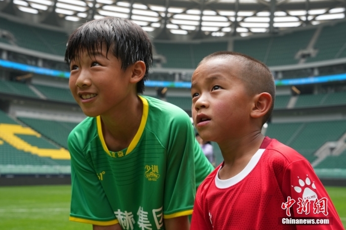 圖為北京國安小球員陳小北和7歲的俄金仁增在一起觀看場內播放的紀錄片。<a target='_blank' href='/' _fcksavedurl='/'><p  align=