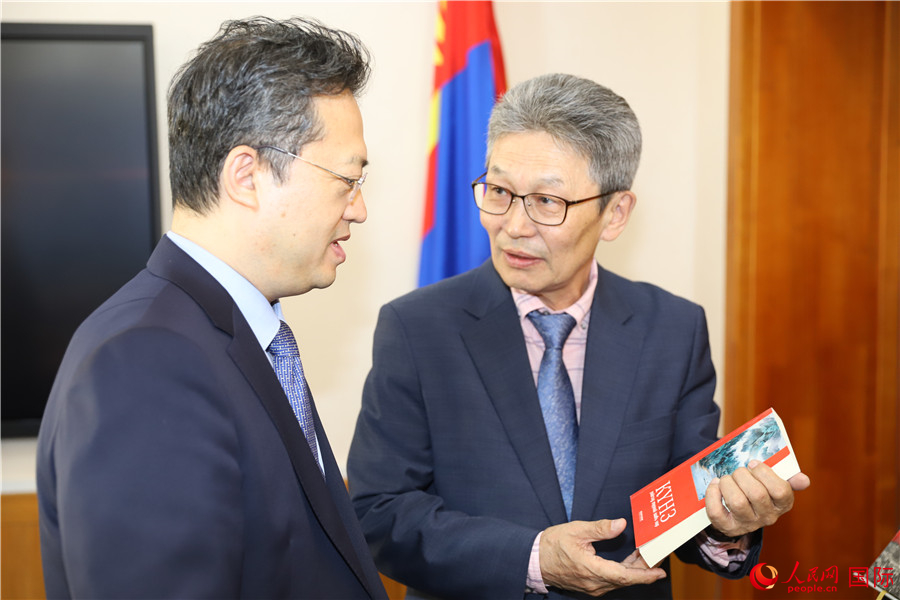 其米德策耶（右一）向李峙介紹翻譯成果。人民網記者 霍文攝