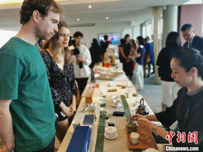 現場觀眾觀看中國展臺茶藝表演、了解茶文化?！【笜?攝