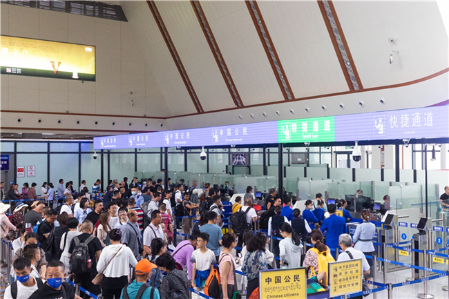 7月22日，乘坐中老鐵路國際旅客列車的旅客在磨憨邊檢大廳排隊候檢。衛海林 攝