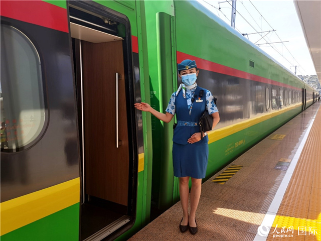 趙瑩靜站在“復興號”國際旅客列車車廂門口歡迎旅客上車。人民網 杜明明攝