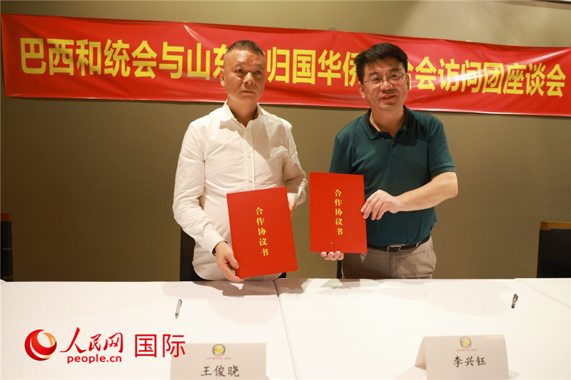 中國僑聯副主席、山東省僑聯主席李興鈺（右）與巴西和統會會長王俊曉簽署合作協議書。人民網記者 陳海琪攝