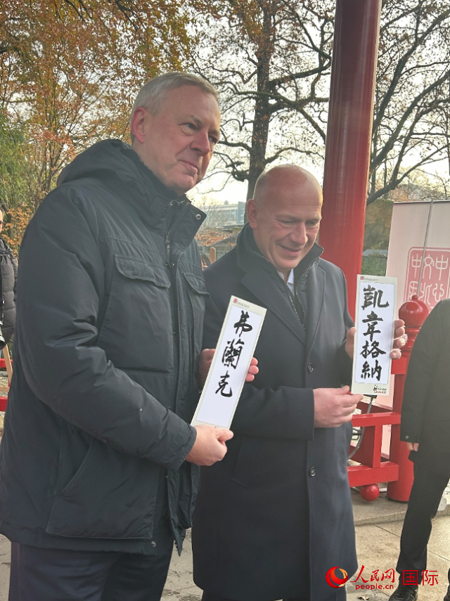 柏林市長韋格納（右）、動物園監事會主席布魯克曼（左）手持中國文化中心工作人員現場手書的中文名字。人民網記者 徐馨攝