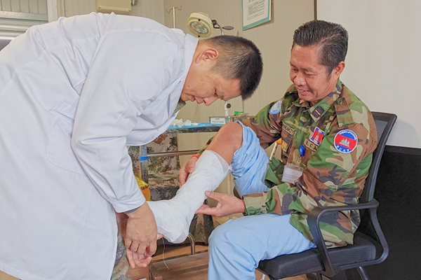 中國第22批赴黎維和醫療分隊軍醫為患者打石膏固定患肢。李清竹攝