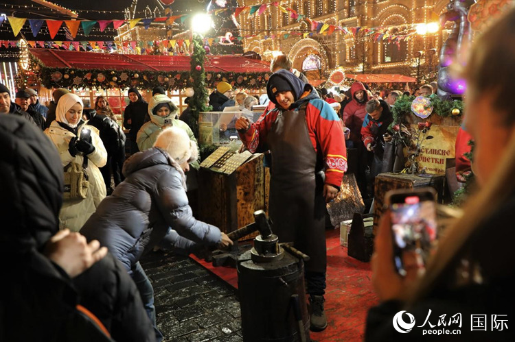 游客在新年集市上體驗制作紀念幣。人民網記者 隋鑫攝