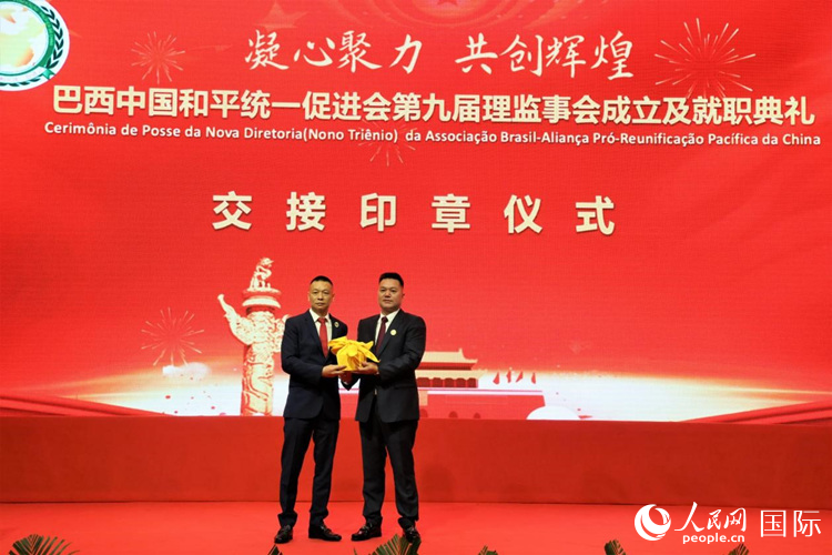 就職典禮中，巴西和統會第七屆和第八屆會長王俊曉與新任會長張小春交接印章。人民網記者 時元皓攝