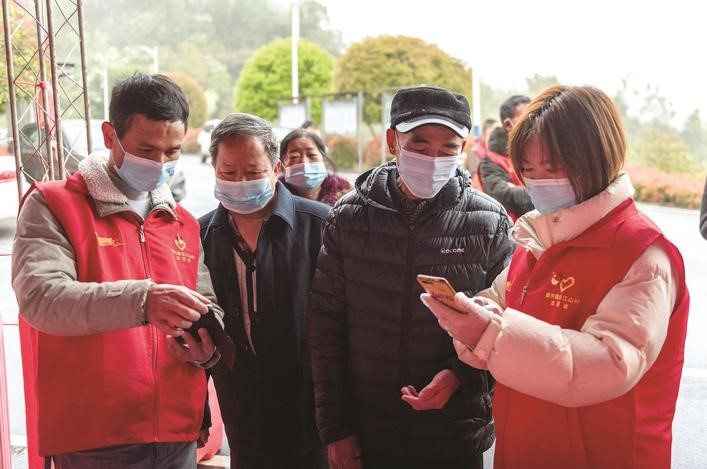 長沙縣黨員志愿者正在幫助參與核酸檢測的群眾掃描“場所碼”。劉思源 攝