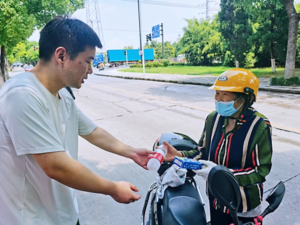 何超為過路的老人送上礦泉水和冷飲。人民網記者 王繼亮攝