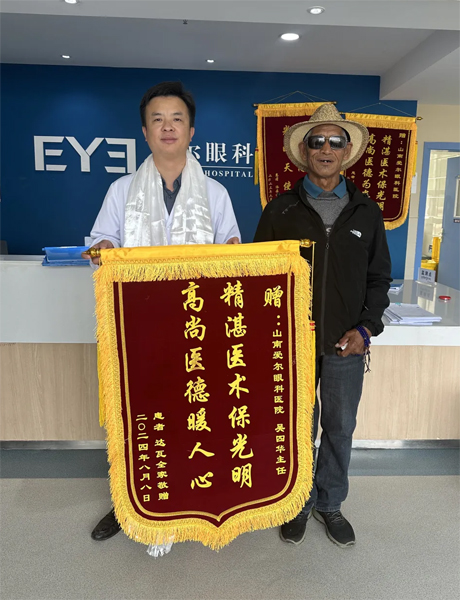 達瓦老人向吳四華（左）贈送錦旗。受訪者供圖