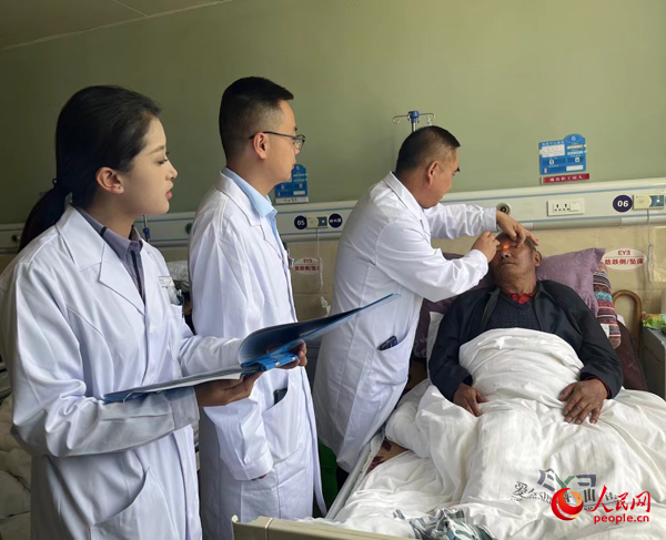 董光明（左三）帶領醫生對患者進行術前檢查。人民網記者 杜燕飛攝