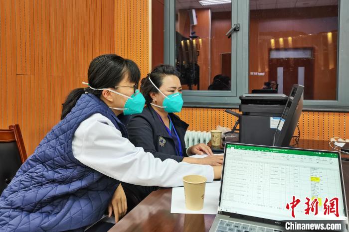 8月9日，楊蘇喬(左)在拉薩方艙醫院指揮部讀取艙內患者胸部CT?！∈茉L者供圖