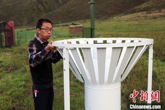 圖為班瑪縣氣象局工作人員在維護藏雪茶基地氣候站。青海省氣象局供圖