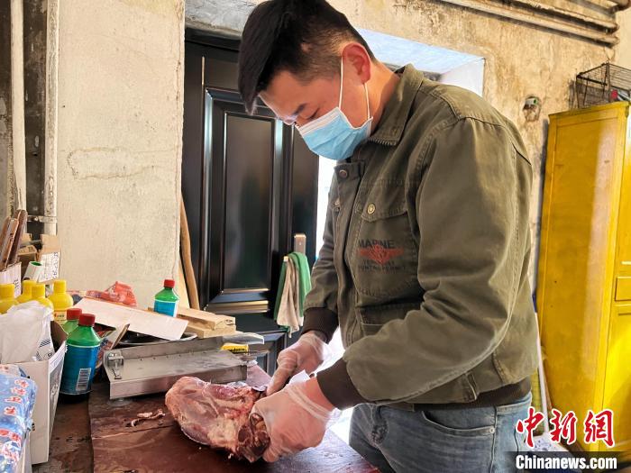 圖為雪豹“奶爸”史壽軍正在準備投喂雪豹的食材?！●R銘言 攝