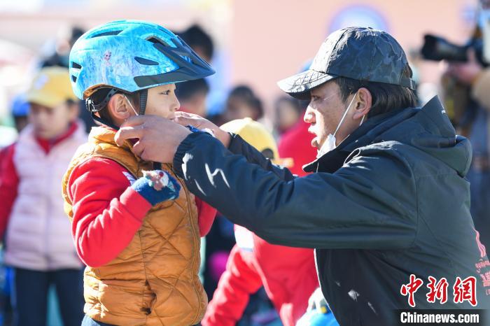 圖為拉薩市實驗幼兒園孩子在教練的幫助下穿戴頭盔?！『闻罾?攝