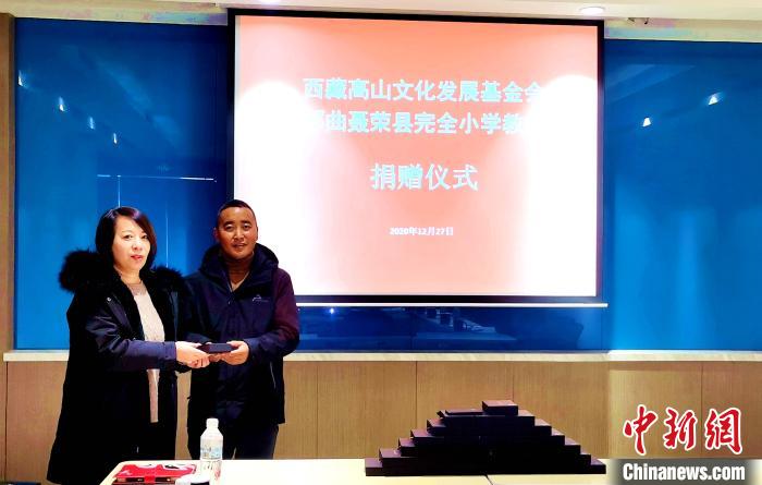 圖為西藏高山文化發展基金會理事長溫麗向聶榮縣完全小學負責人捐助儀器?！∮谫e 攝