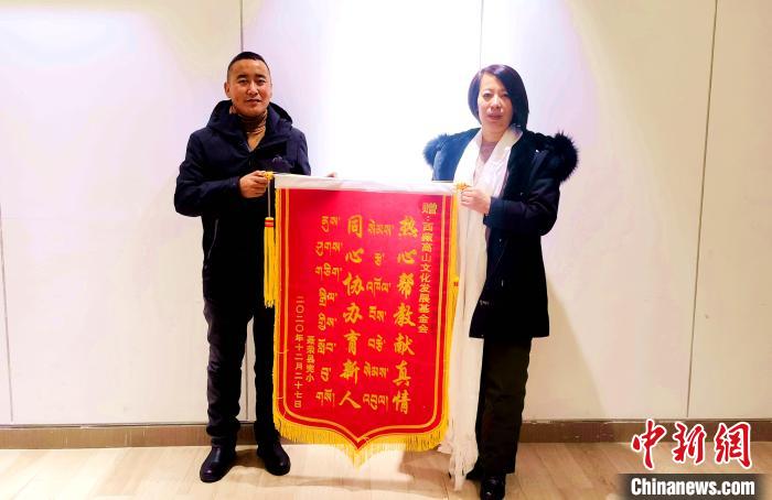 圖為聶榮縣完全小學向西藏高山文化發展基金會贈送錦旗?！∮谫e 攝