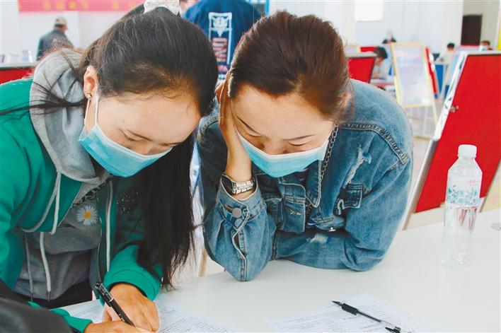 圖為應聘者在填寫報名表。記者 段敏 攝.jpg
