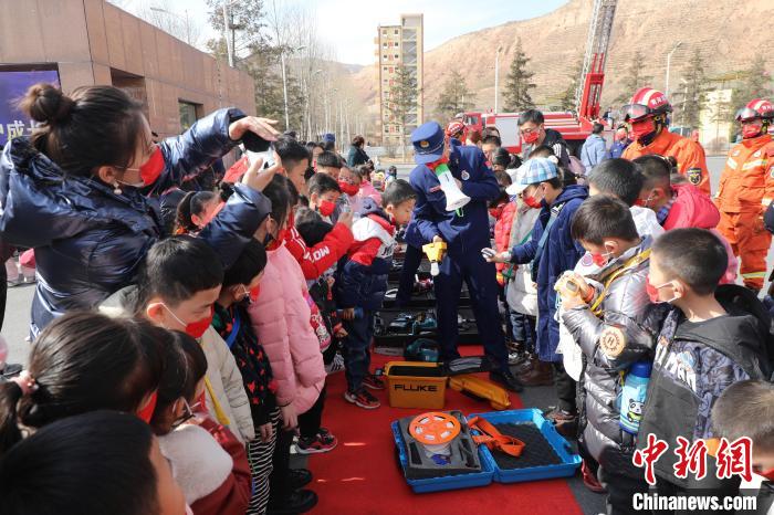 圖為小朋友們聽消防員講解消防器材?！铨埥?攝