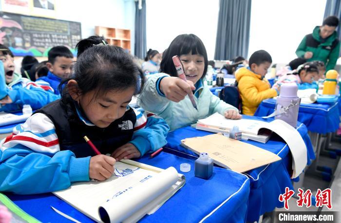 3月14日，西藏拉薩市第一小學一年級六班學生白瑪朗珍(圖左)在藏語文課上書寫藏文?！±盍?攝