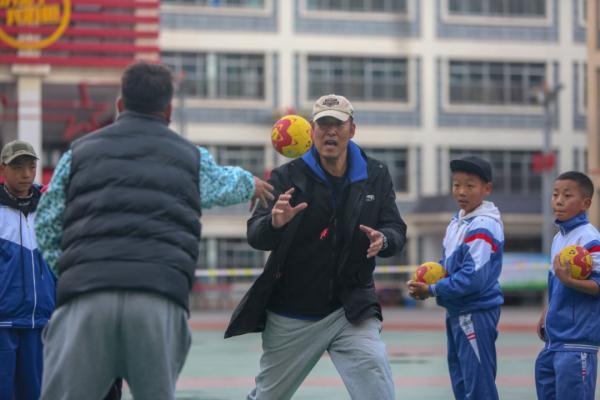 在高原上教孩子們打手球，“慢慢兒來，甭著急！”
