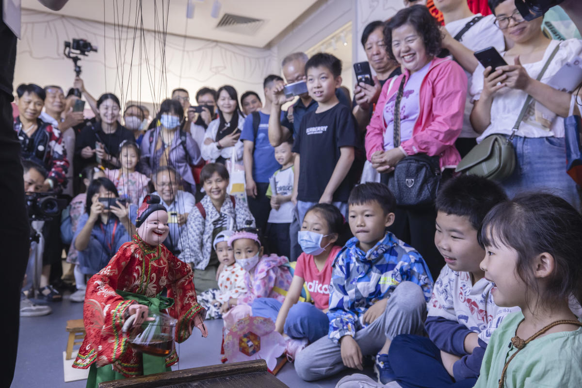 5月1日，廣州市白鵝潭大灣區藝術中心非物質文化遺產館內，精彩的梅縣提線木偶戲表演吸引了眾多游客駐足觀賞。 來源：人民圖片網