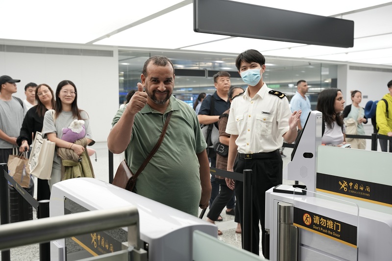 杭州海關所屬杭州蕭山機場海關關員引導國外旅客通過一體化智能閘機進行通關。周雨亮攝