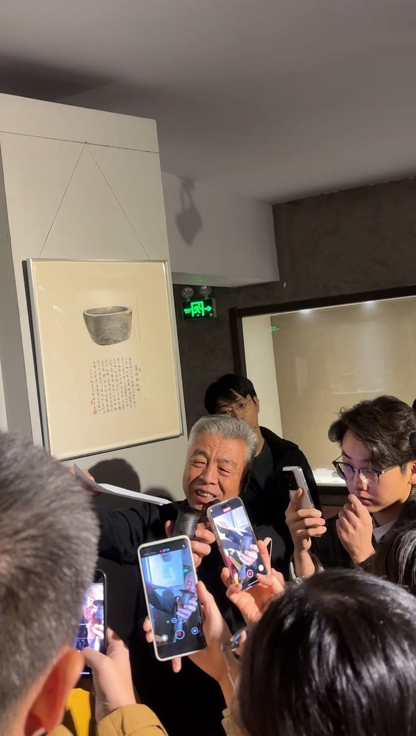 黑陶邢文化博物館館長邢葆東展示兩張相疊的A4紙，向記者解釋此為杯口的厚度。