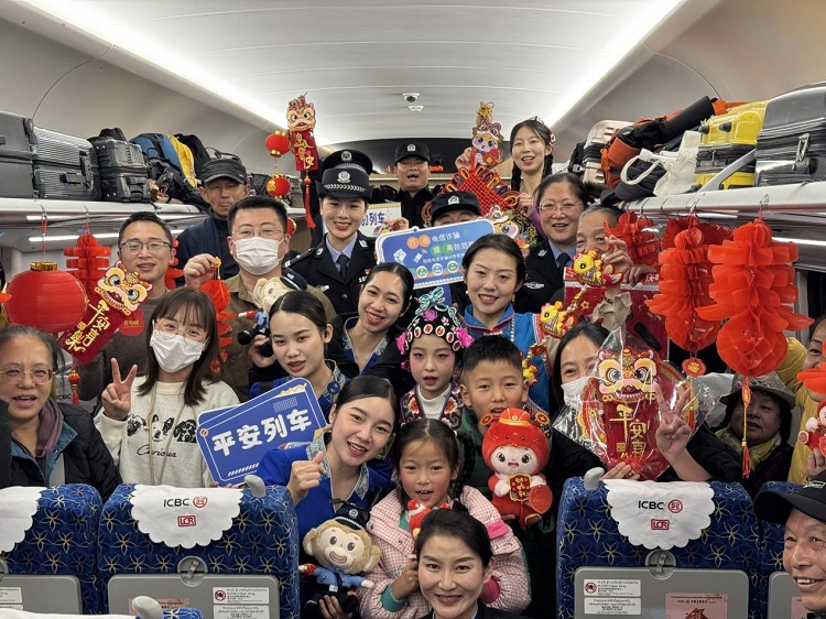 春節期間，在中老鐵路磨萬（磨丁—萬象）段，鐵路客運員工與乘客合影留念。李加勇攝