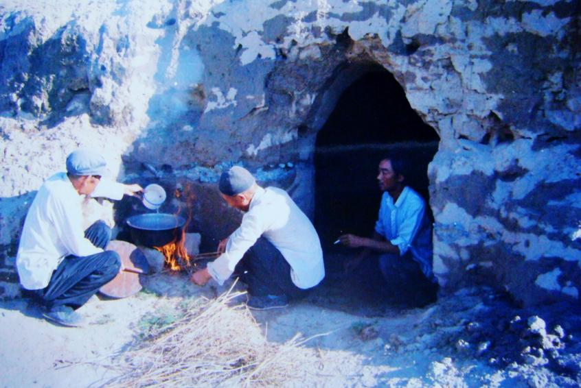 1983年，“六老漢”一代治沙人在“地窩子”生活做飯。新華社發（八步沙林場供圖）