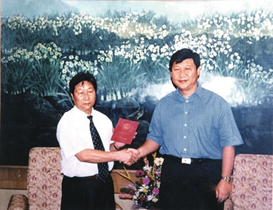 2000年7月，習近平為福建農林大學教授林占熺頒發福建省政府“一等功”榮譽證書。圖源：《習近平在福建》（下）