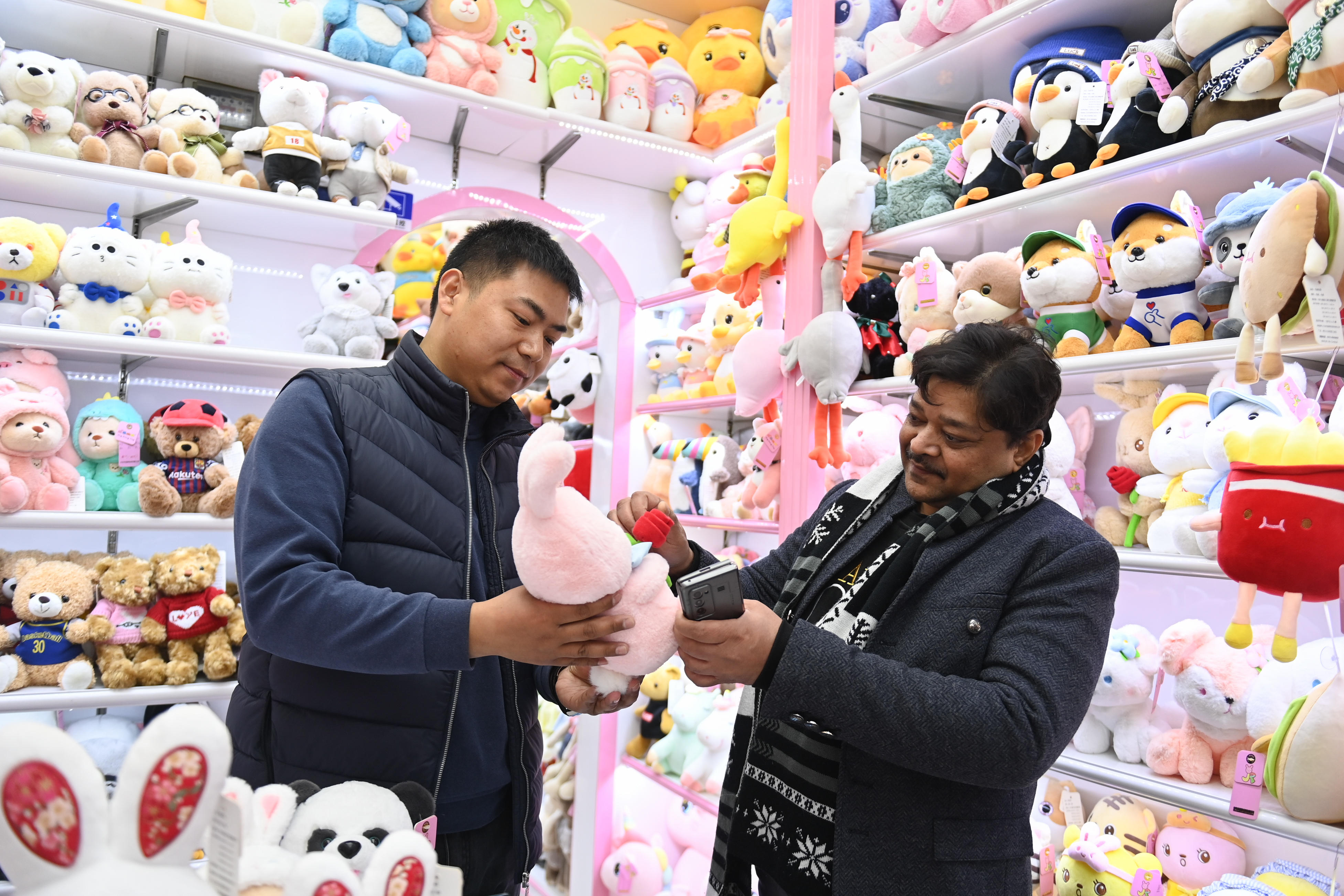 2023年2月2日，來自印度的客商（右）在義烏國際商貿城的一家玩具店鋪內選購。