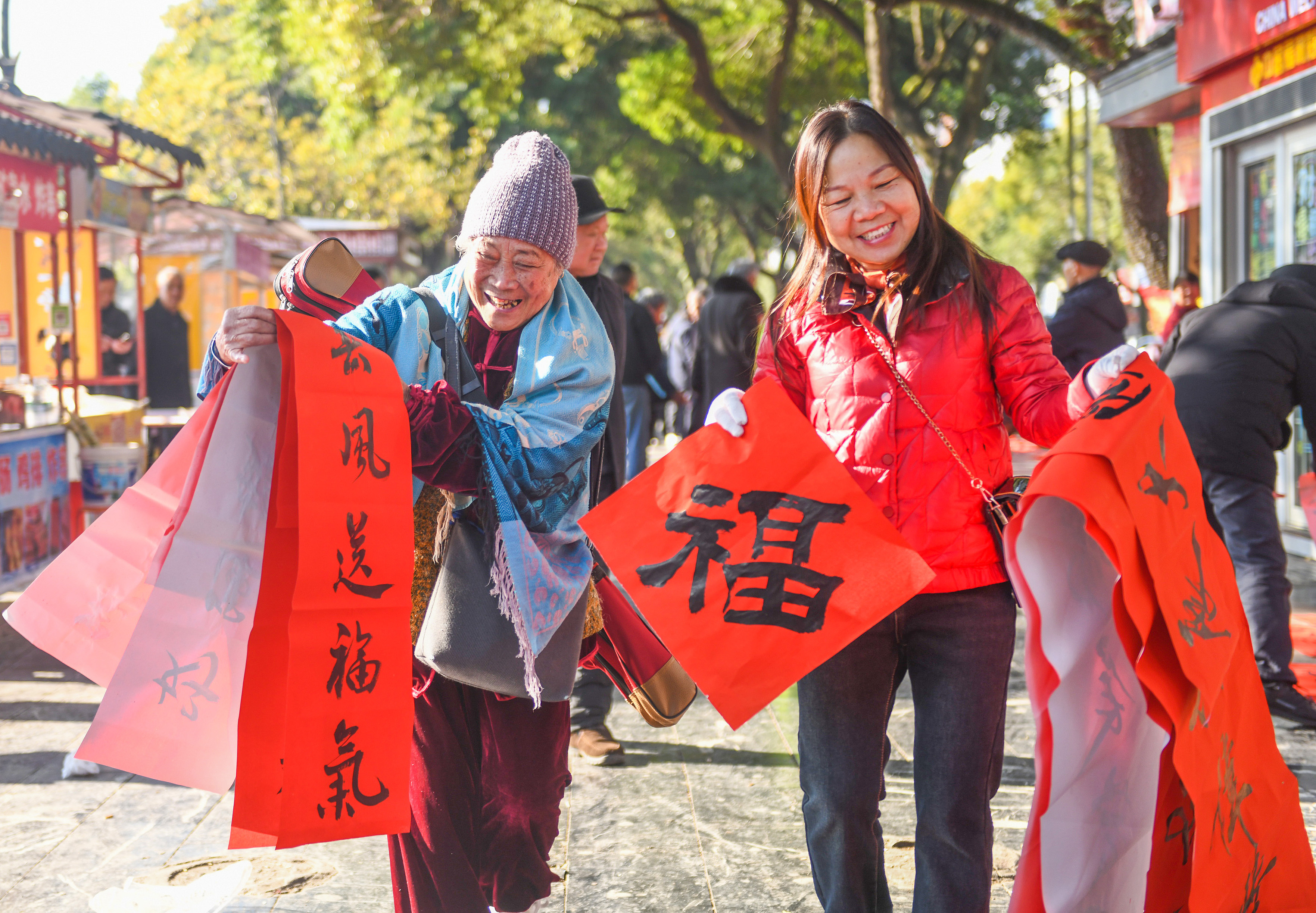 2025年1月13日，在湖南省永州市道縣西洲公園義工崗亭，市民們領到了書法志愿者為大家書寫的春聯。