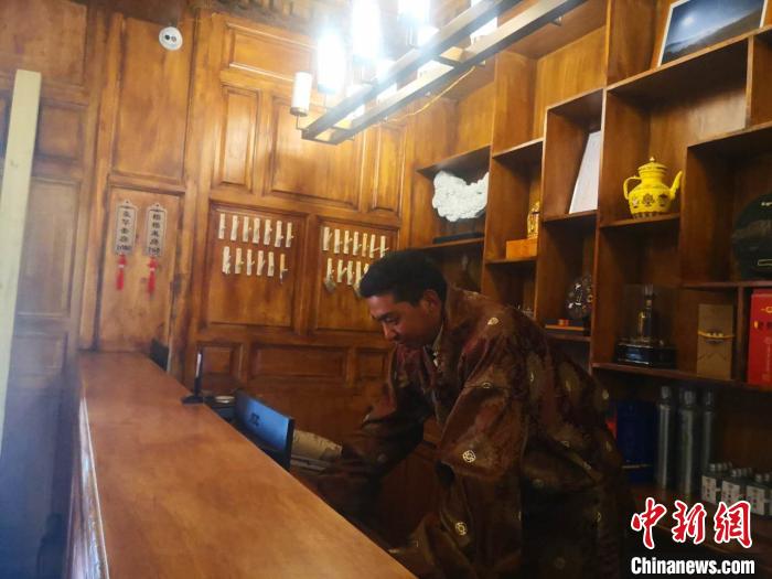 圖為桑杰才讓用電腦處理財務?！∈缝o靜 攝