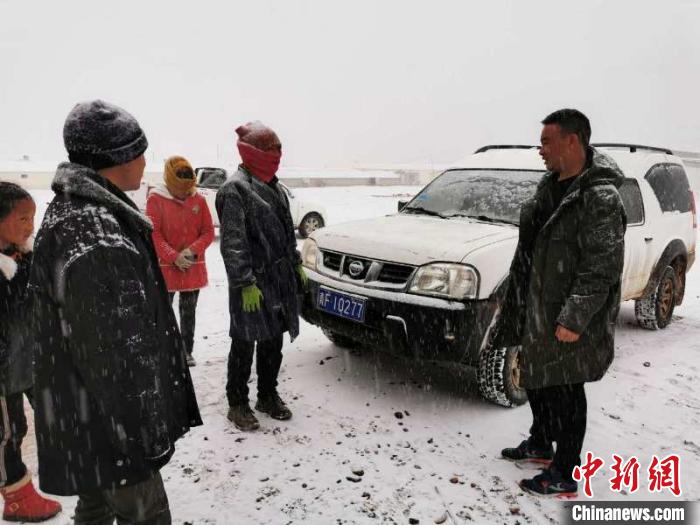 圖為扎西鬧吾(右一)與當地牧戶交談。郵儲銀行青海省分行供圖