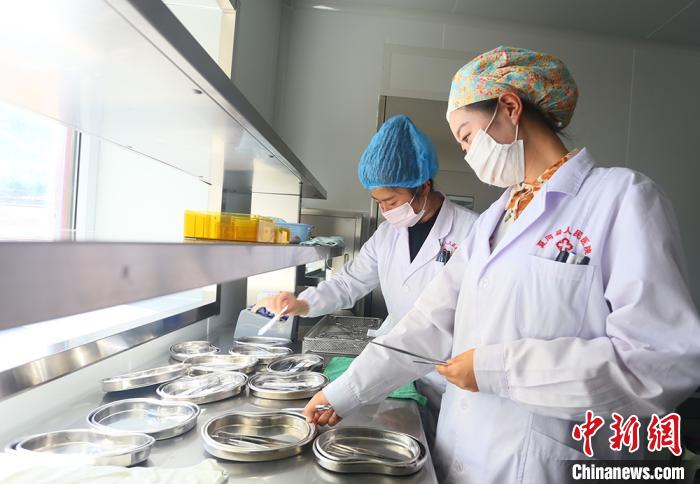 7月下旬，夏河縣人民醫院醫生進行手術用具的消毒清潔?！「哒?攝