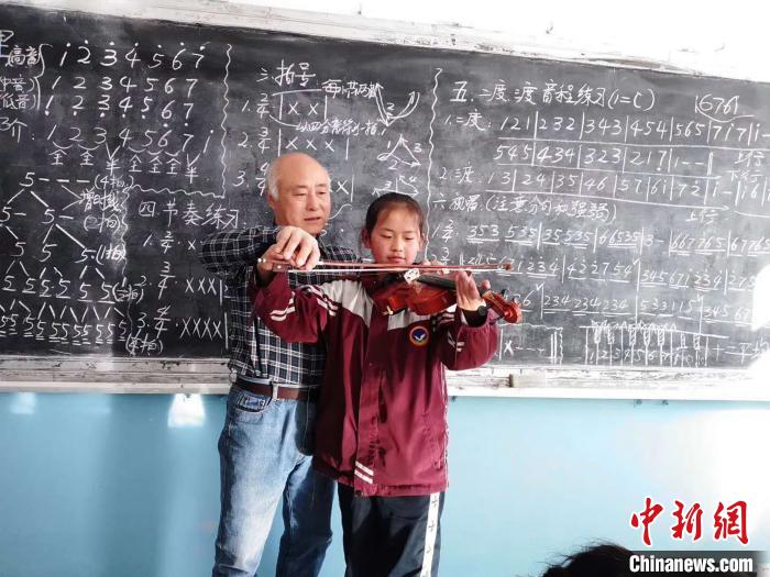 圖為趙興洲教學生拉小提琴。受訪者提供